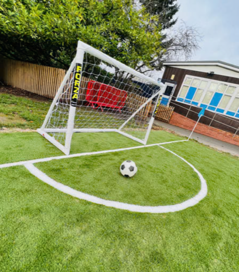 Artificial football pitch with goal and football