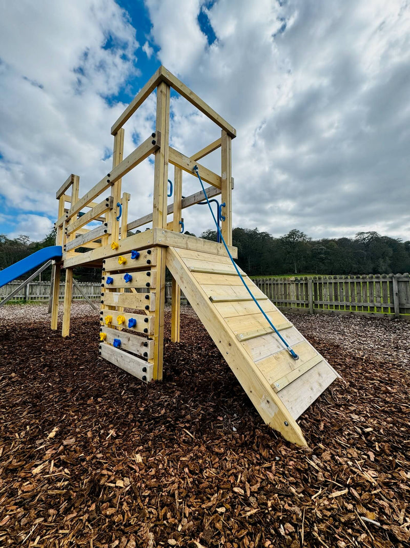 Outdoor playset with climbing wall and slide