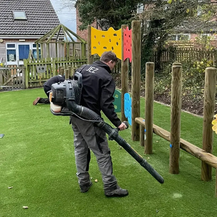 Play area being maintained with a leaf blower