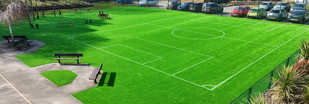 Play area with benches and an artificial football pitch